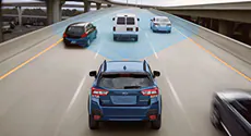 A blue Subaru in a center lane with three cars in front and a blue field from the Subaru's front.
